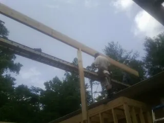 Carpenter setting a ridge beam over a new addition frame — Ice Dam Removal by Roofing Brothers in Highspire