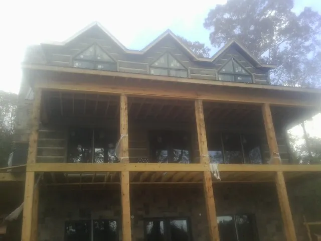 Dormers and porch framing on a large log home under construction — Roof Coating work by our crew in Highspire