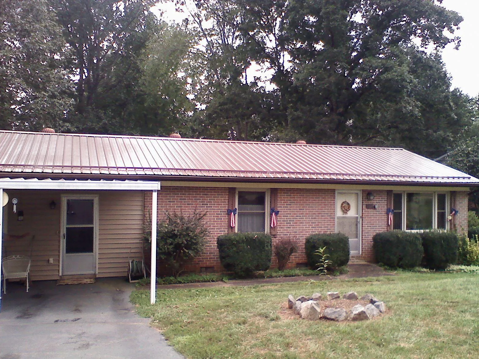 Bronze metal roof and carport on a brick ranch home — Roof Repair work by our crew in Highspire